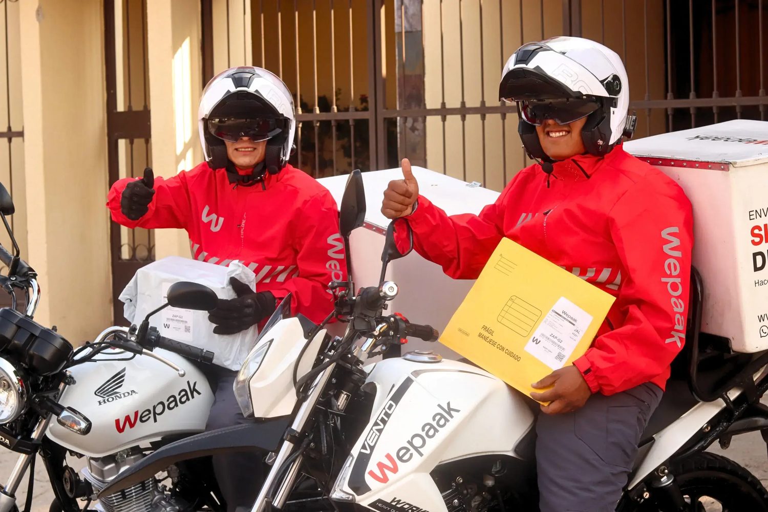 Repartidores de Wepaak en moto con paquetes
