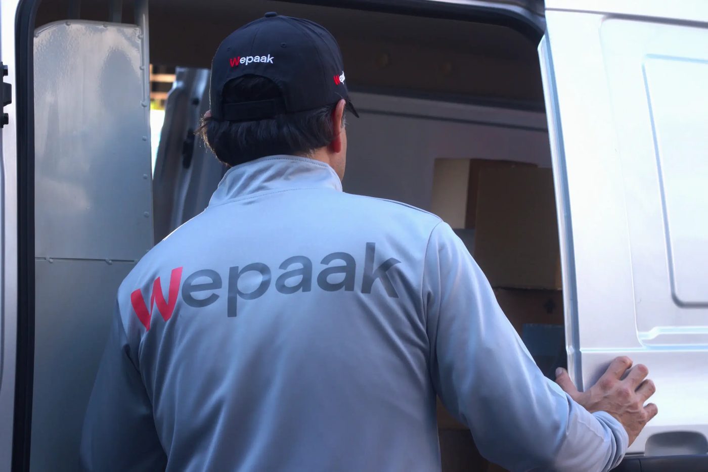 Equipo de Wepaak cargando paquetes en una camioneta
